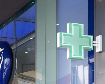 Sign green pharmacy cross above the boots chemists store in brig